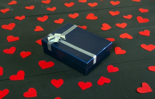 Черная коробка с красными сердечками на столе