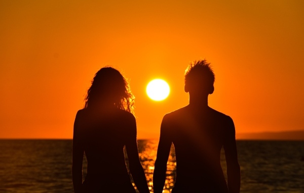 Влюбленная пара на фоне заката у моря