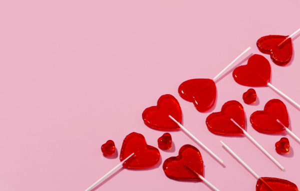 Леденцы в форме сердца на розовом фоне