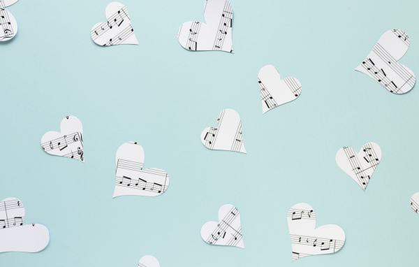 Сердечки из нотной тетради на голубом фоне