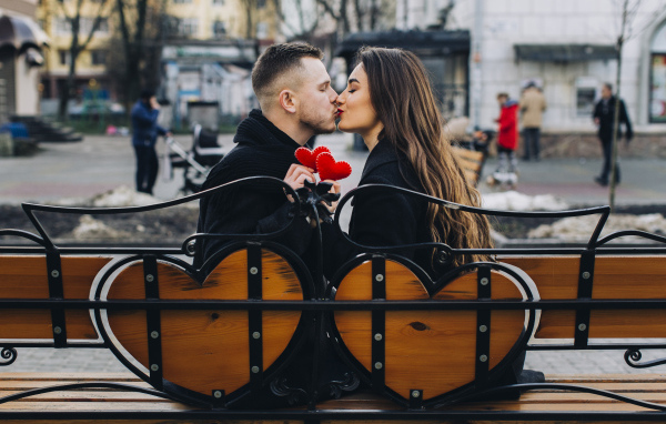 Поцелуй влюбленной пары на лавке в парке