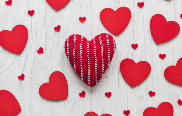 Много красных сердец на белом деревянном столе