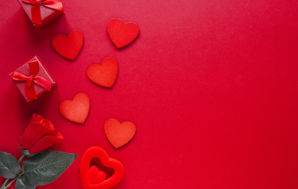 Бумажные сердечки с подарком и розой на красном фоне
