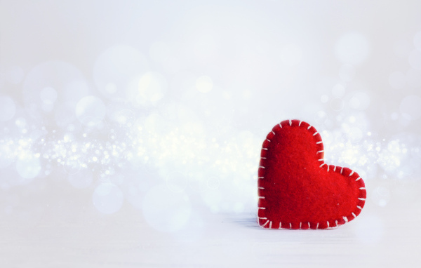 Красное тканевое сердце на сером фоне