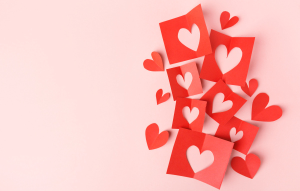Сердечки из красной бумаги на сером фоне