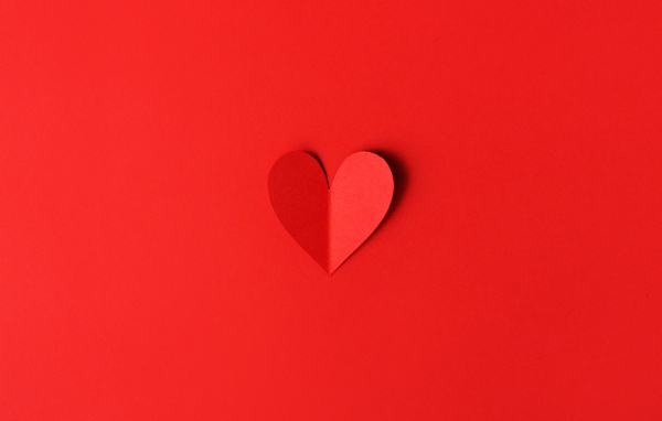 Маленькое бумажное сердце на красном фоне