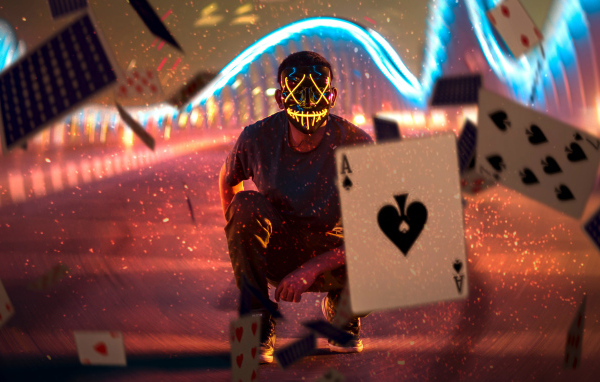 Мужчина в маске бросает карты