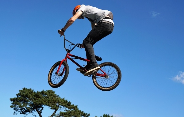 Мужчина делает прыжок на велосипеде на фоне неба