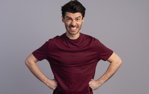 Злой мужчина на сером фоне