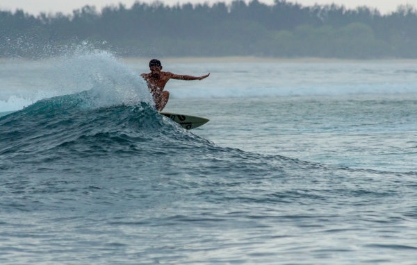 Мужчина серфингист ловит волну