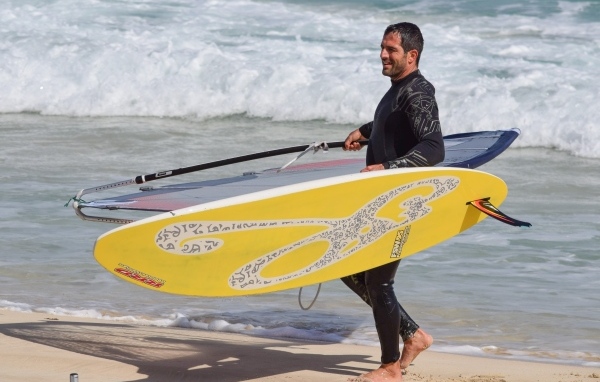 Мужчина серфер с доской на пляже