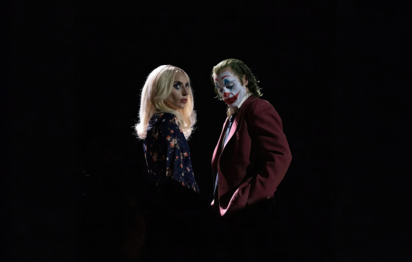 Главные герои фильма Джокер: Безумие на двоих на черном фоне