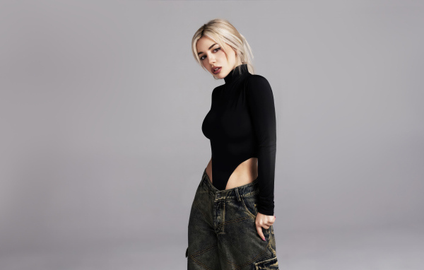 Милая блондинка певица  Эйва Макс на сером фоне