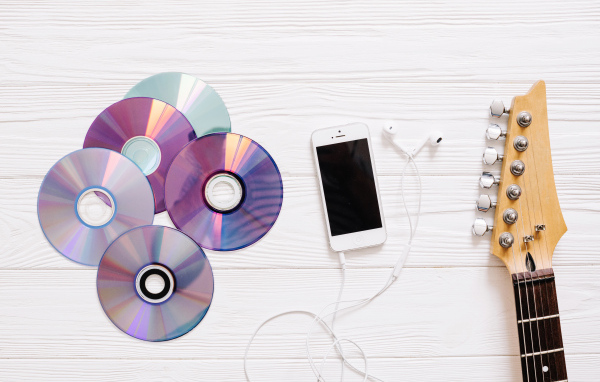 Диски с телефоном и гитарой на белом фоне