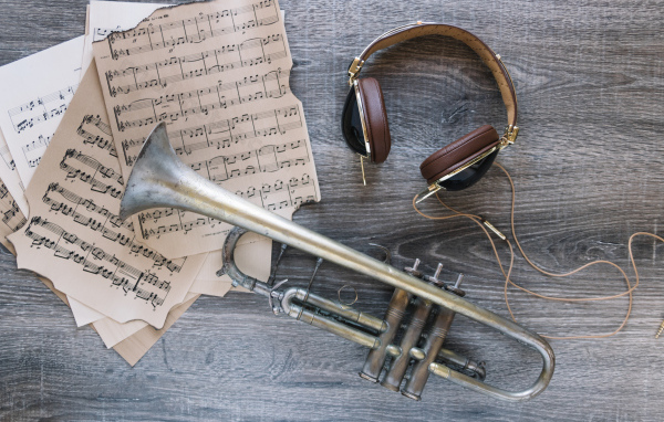 Старые ноты, наушники и труба на столе
