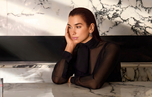 Грустная певица Дуа Липа сидит за столом