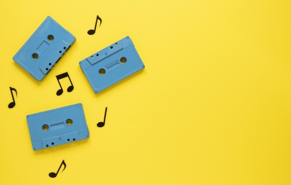 Три голубые кассеты с нотами на желтом фоне