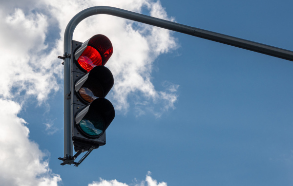 Красный свет светофора на фоне неба