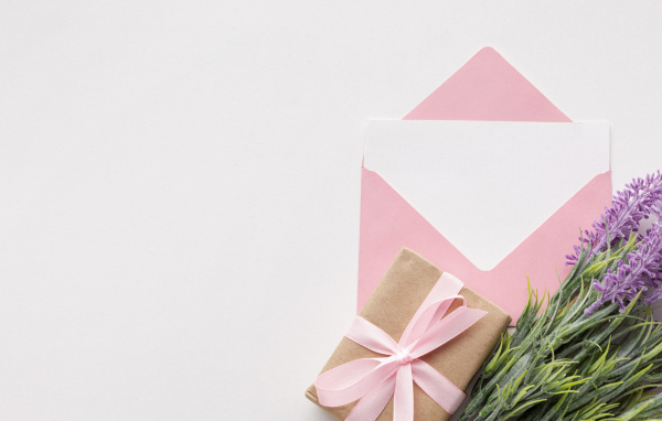 Конверт с цветами и подарком на белом фоне