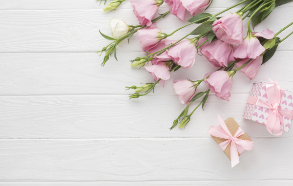 Нежна розовая эустома с подарками на белом фоне