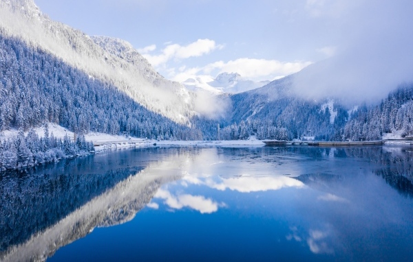 Покрытые снегом горы у покрытого льдом озера