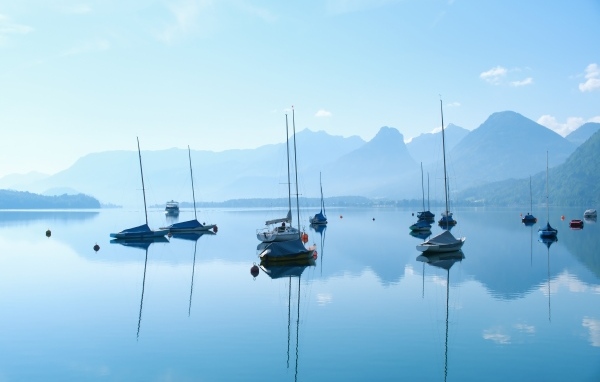 Лодки на озере у гор на рассвете в тумане