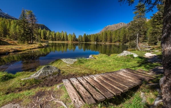 Мост на берегу озера в горах под голубым небом