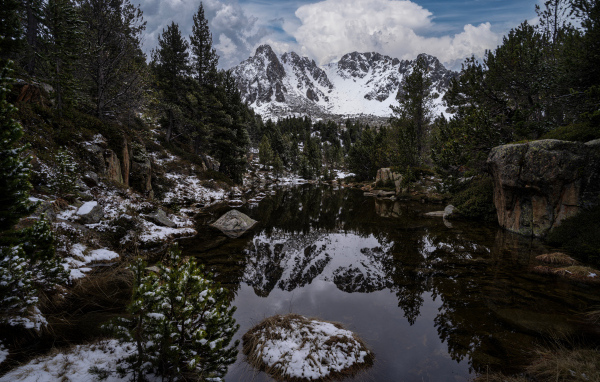 Холодная вода в озере с большими камнями на фоне гор