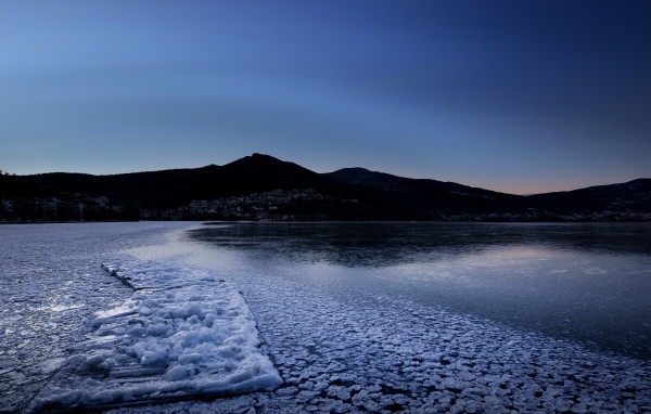 Заледеневшая вода в горном озере в сумерках