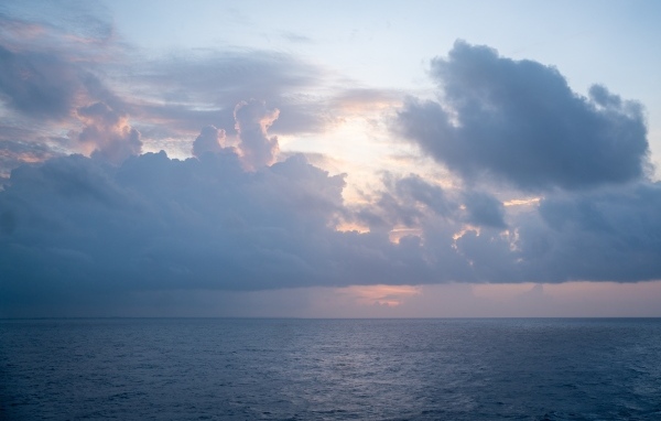 Густые белые облака над морем на рассвете летом