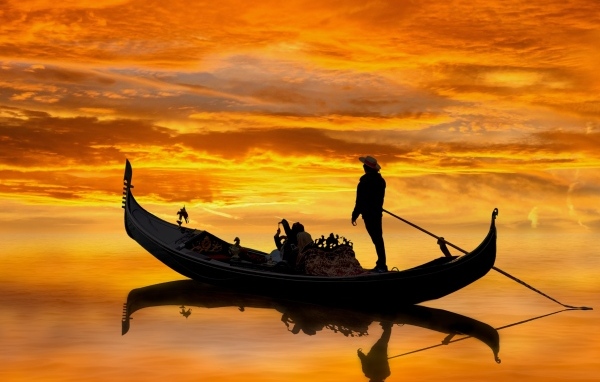 Мужчина на гондоле на закате