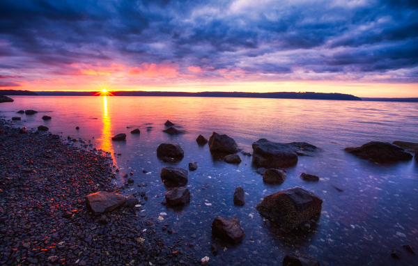 Закат солнца в пасмурном небе у озера