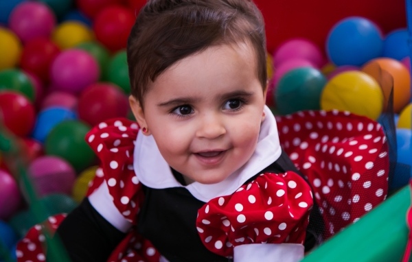 Кареглазая девочка в бассейне с шариками