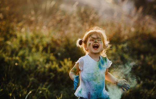 Веселая девочка в краске на улице