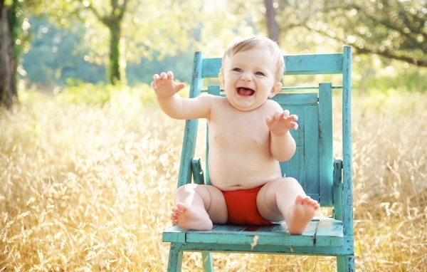 Веселый маленький мальчик в кресле 