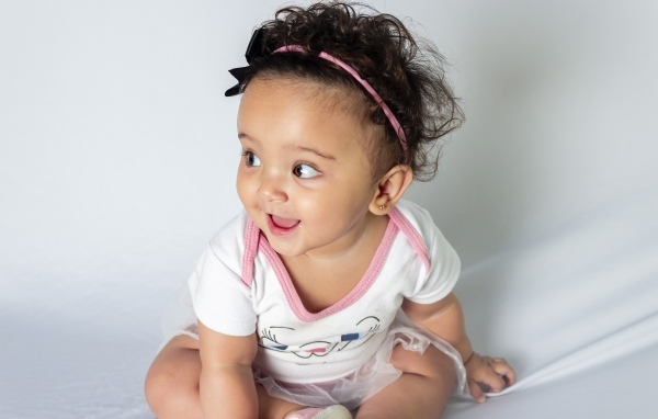 Веселая маленькая девочка с ободком на голове