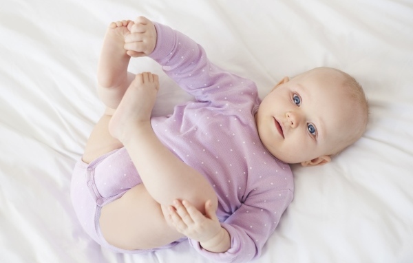 Милый голубоглазый малыш на белом покрывале