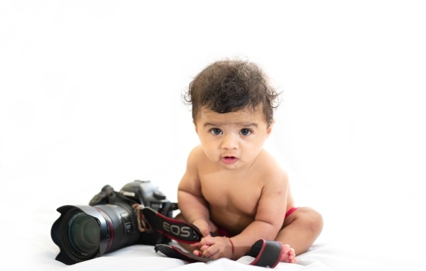 Милый ребенок с фотоаппаратом на белом фоне