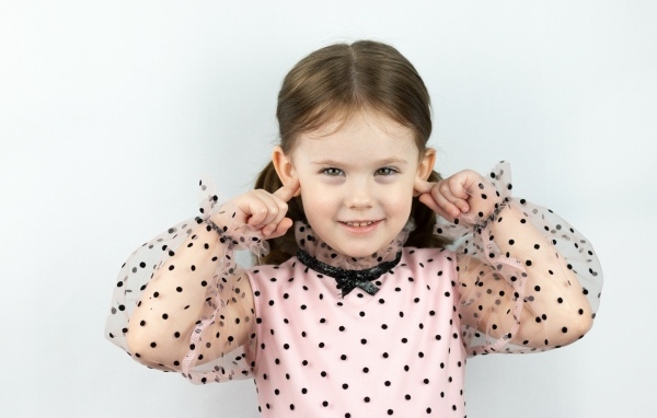 Смешная маленькая девочка закрыла уши