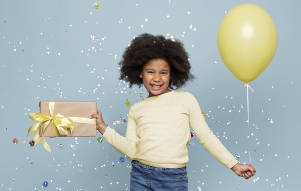 Счастливая девочка с подарком и шариком на голубом фоне