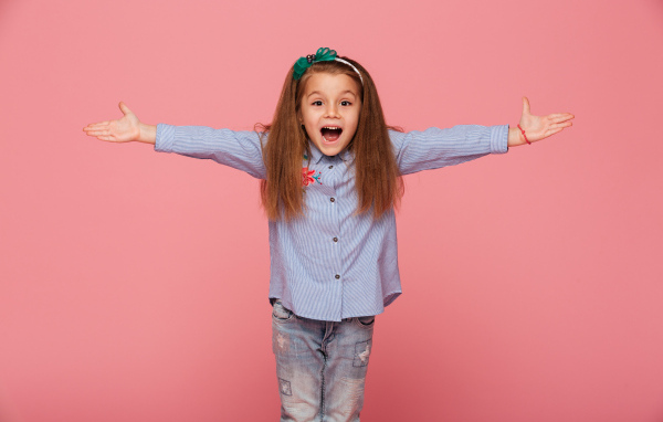 Счастливая маленькая девочка на розовом фоне