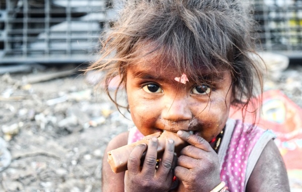 Маленькая азиатская девочка с конфетой в руках