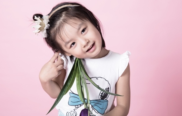 Маленькая девочка азиатка на розовом фоне