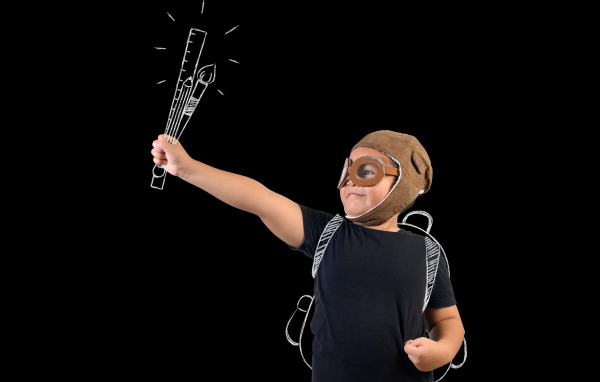 Маленький мальчик с нарисованными кистями на черном фоне