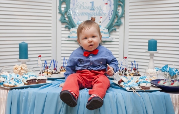 Маленький ребенок с угощениями на день рождения
