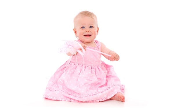 Маленькая девочка в розовом платье на белом фоне