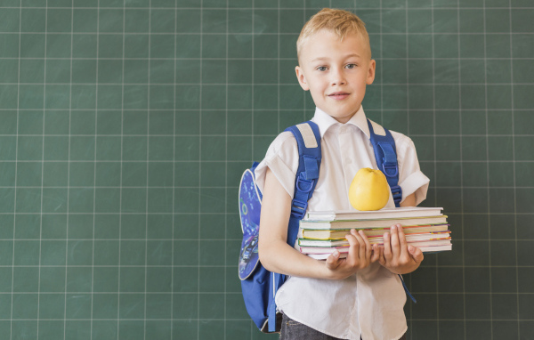 Мальчик школьник с книгами у доски