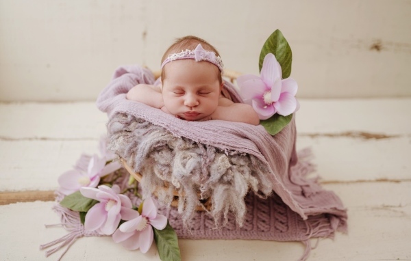 Спящая новорожденная малышка с цветами