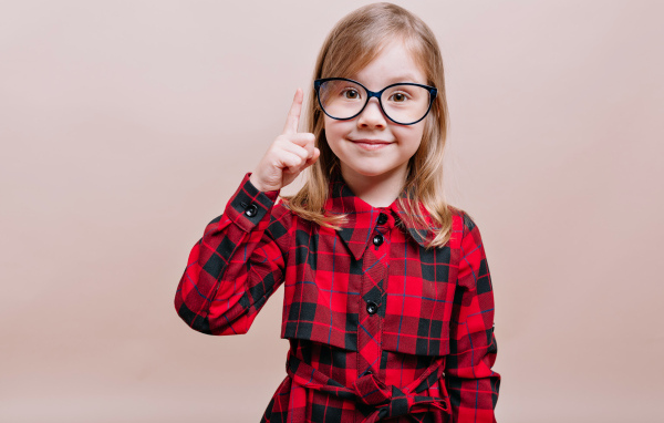 Умная маленькая девочка в платье в очках