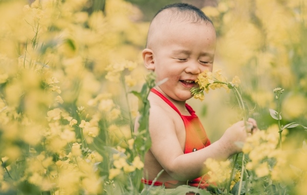 Улыбающийся ребенок на поле с желтыми цветами